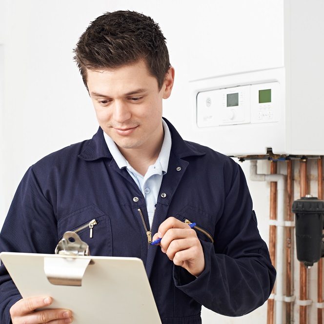 Male Plumber Working On Central Heating Boiler